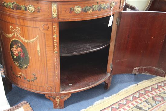 An Edwardian Sheraton revival painted satinwood demi lune side cabinet, W.3ft 8in. D.1ft 10in. H.2ft 10in.